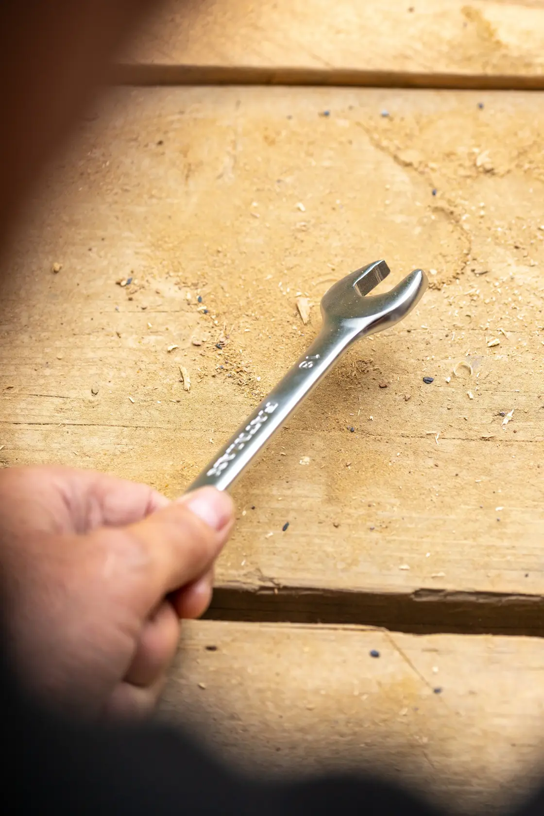 Photo of STANLEY FMMT13066-0 open-end wrench held in hand on a wooden work surface.