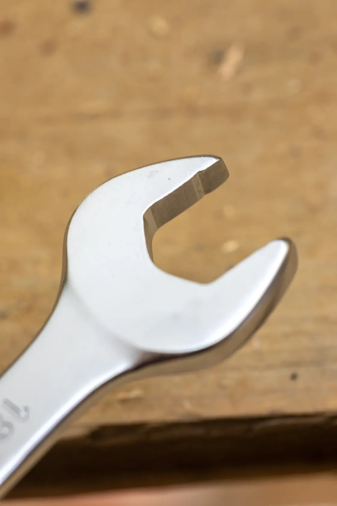 STANLEY FMMT13068-0 open-end wrench close-up on wood surface, silver finish, photography product.