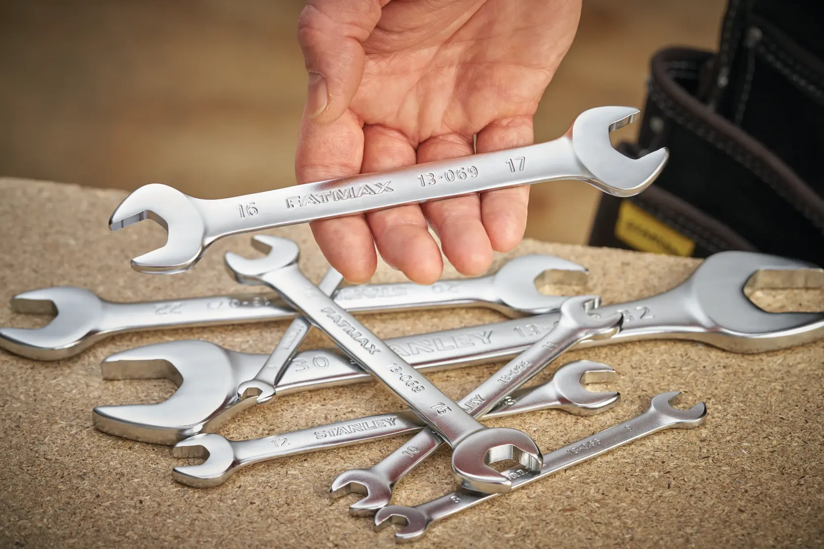 STANLEY FMMT13069-0 photography of chrome combination wrenches with hand holding one above others.