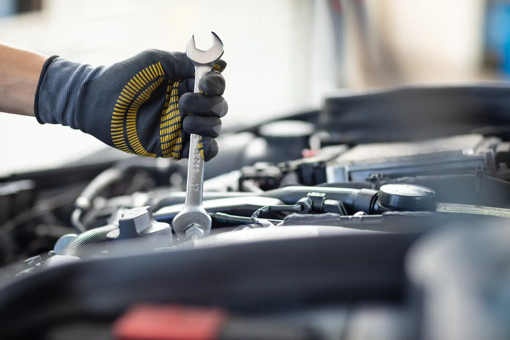 Photography of STANLEY FMMT13073-0 wrench in gloved hand working on car engine.