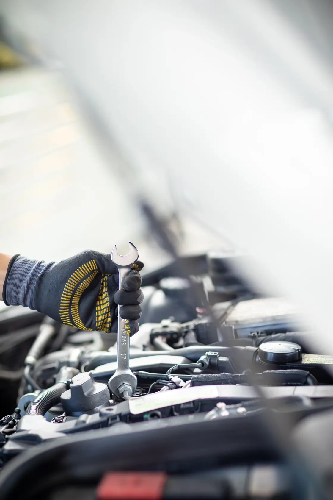 Photo of STANLEY FMMT13074-0 spanner in a gloved hand tightening a bolt in a car engine bay.