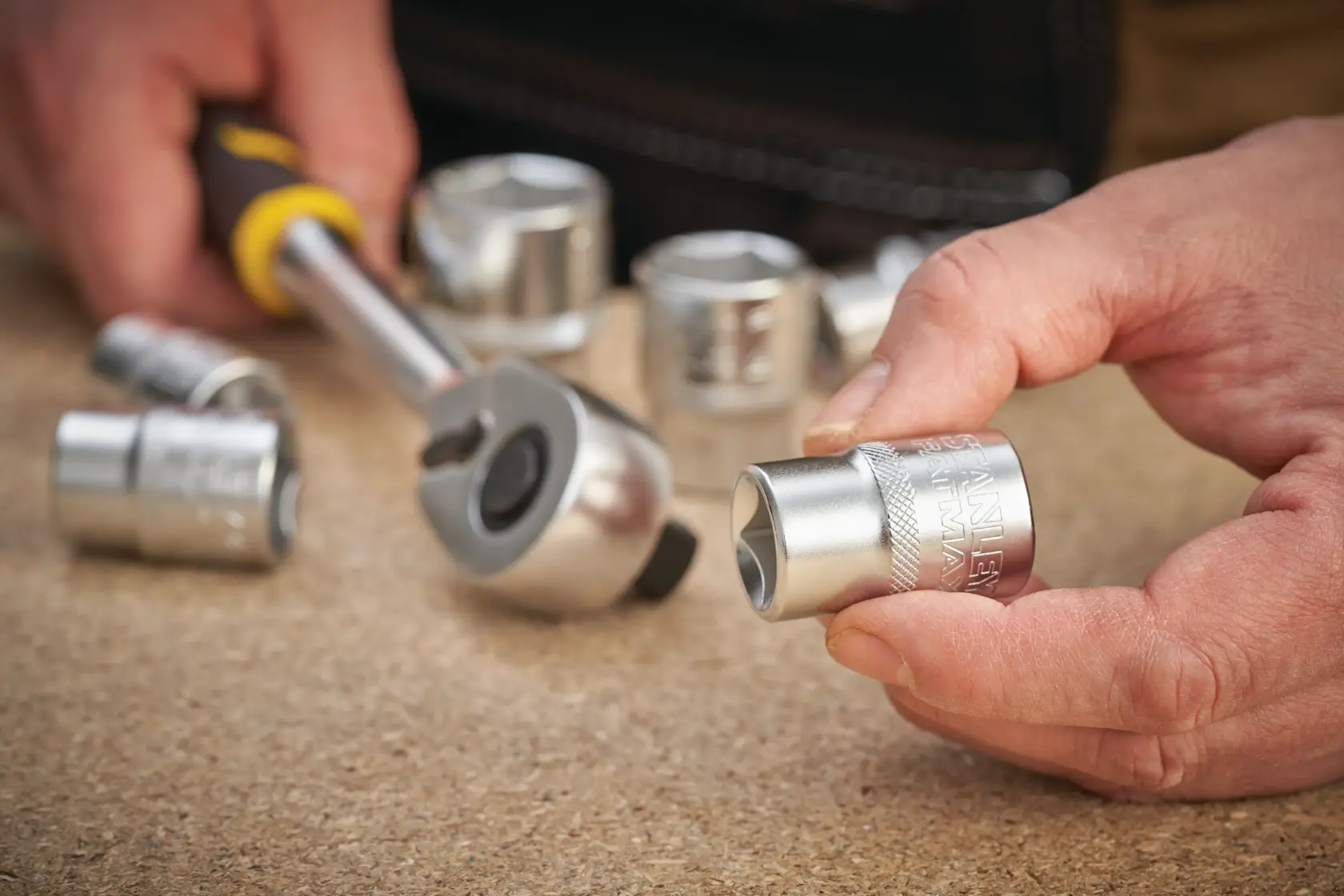 STANLEY FMMT17232-0 socket with ratchet tool held by hand, silver finish, close-up photography.