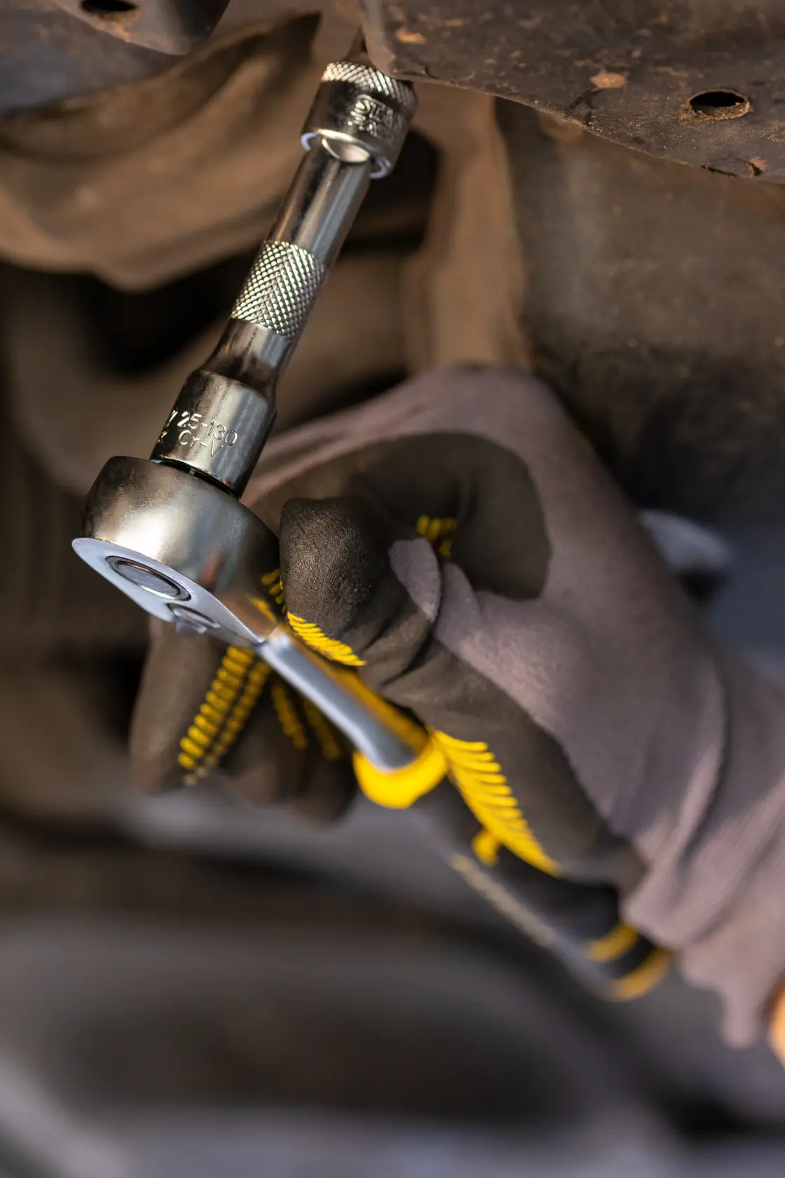 Stanley FMMT25122-0 ratchet tool in use, close-up, showing yellow and black handle grip.